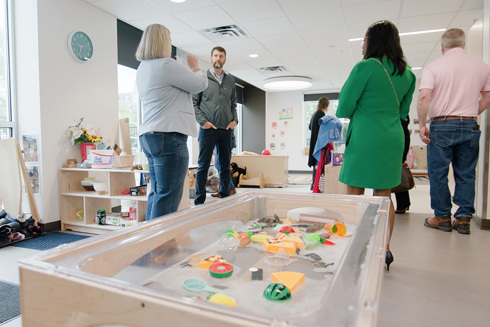 men and women standing in a classroom