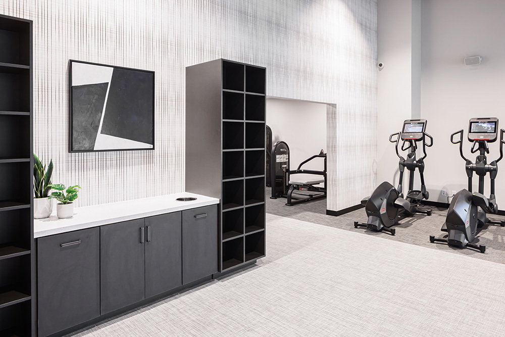 fitness center in an apartment building with a row of exercise equipment