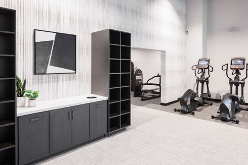 fitness center in an apartment building with a row of exercise equipment