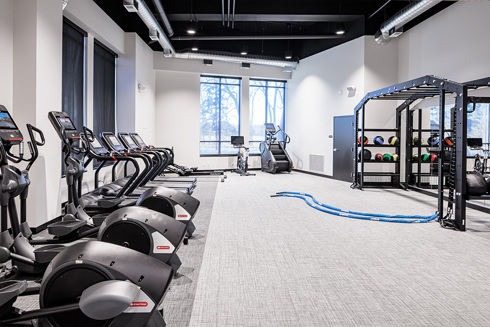 fitness center in an apartment building with a row of exercise equipment