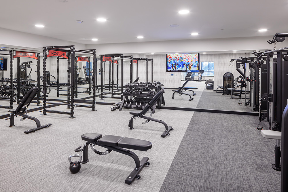 fitness center in an apartment building with a row of exercise equipment