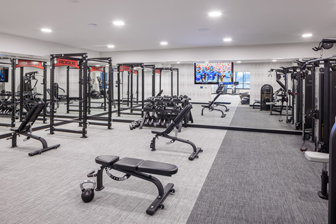 fitness center in an apartment building with a row of exercise equipment