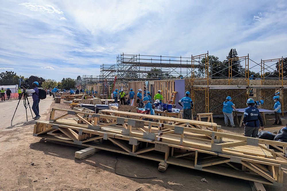 many people work together to frame the exterior of a home