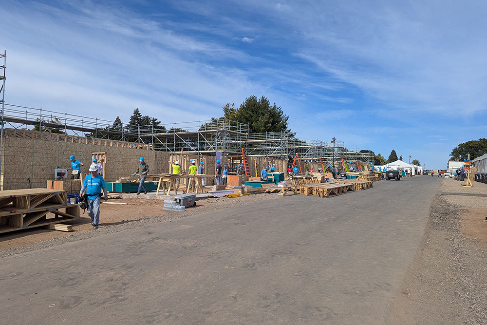 a long depth view of many homes under construction with exterior framing going up