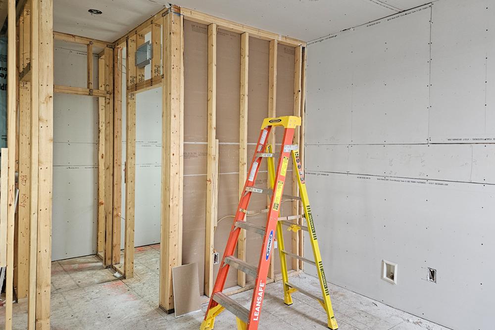 the interior of a home under construction with some open wood framing and some installed drywall