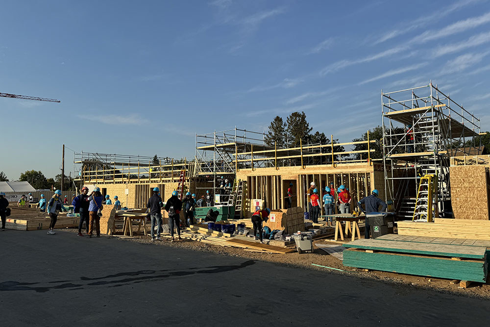 a long depth view of many homes under construction with exterior framing going up