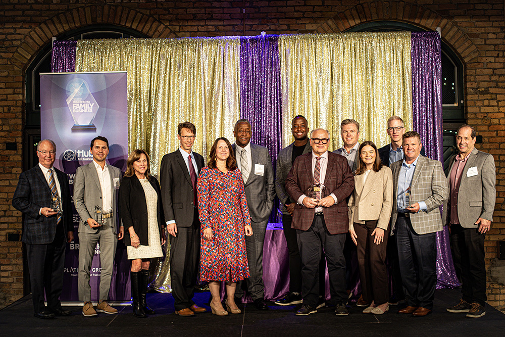 group of people standing on a stage with some of the people holding awards