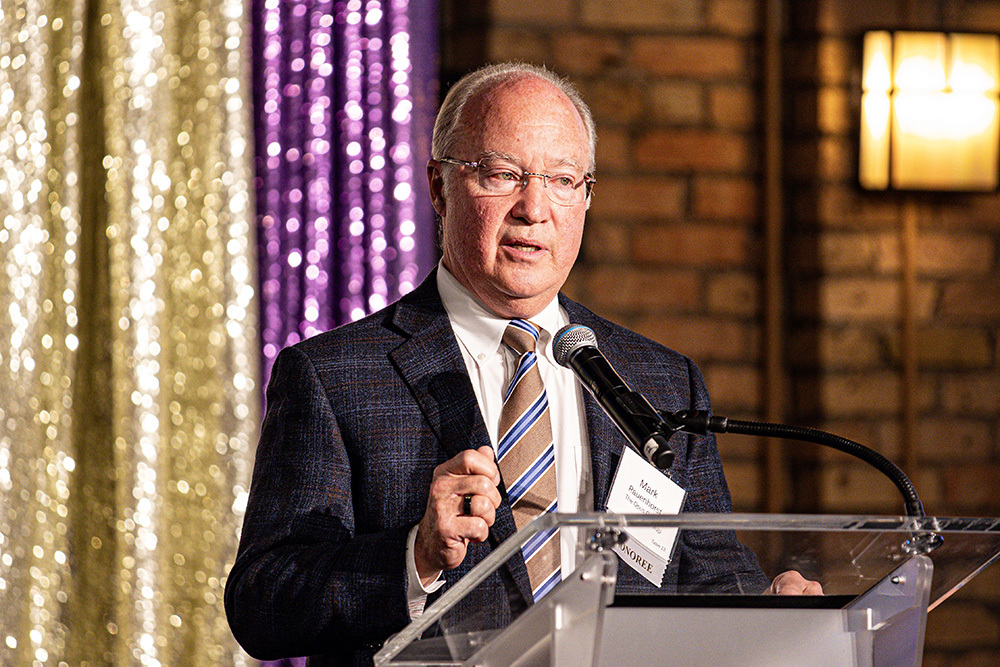 man speaking at podium on a stage