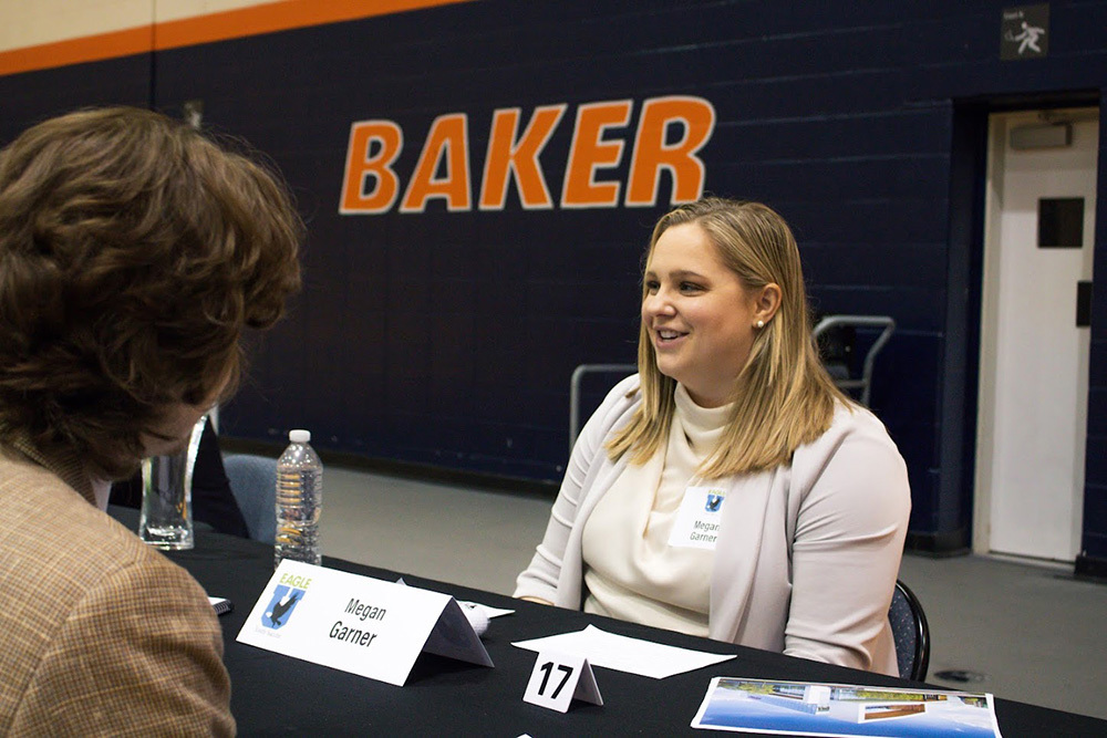 woman in professional attire sitting at a table