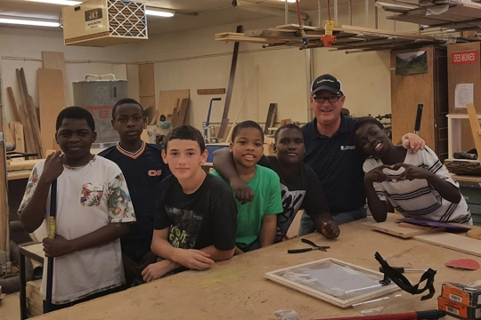 man with group of boys in carpentry classroom