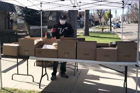 Man standing outside by table with boxes