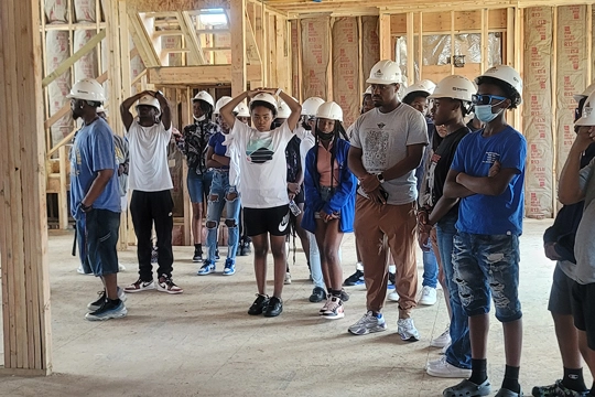 children in hard hats inside construction site