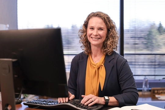 woman in professional attire at computer