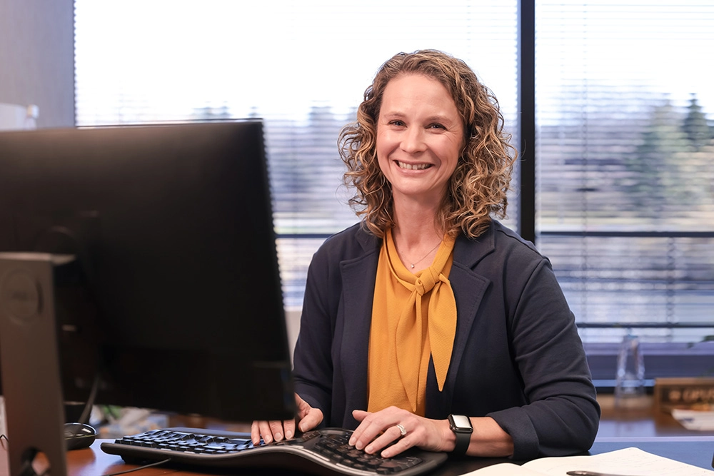 woman in professional attire at computer