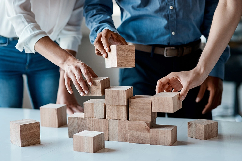 hands stacking wood blocks