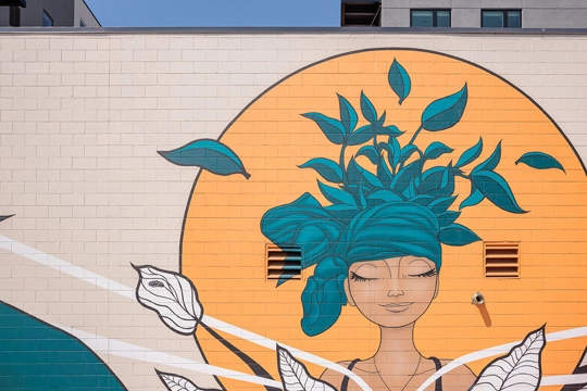 mural of woman with green hat made of leaves