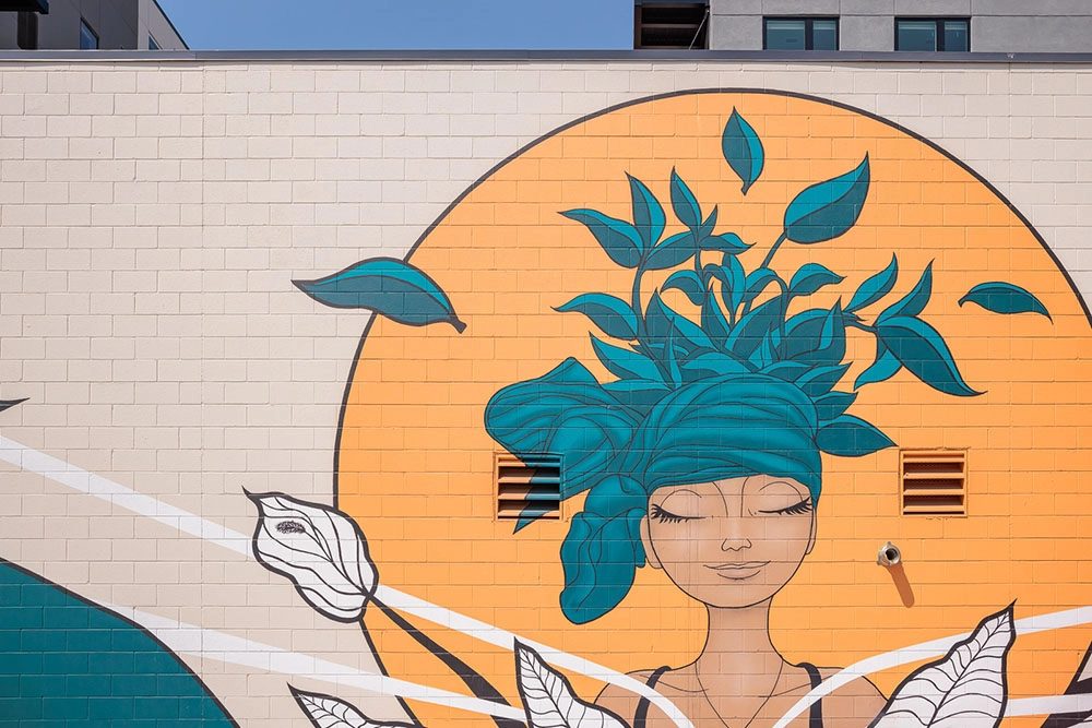 mural of woman with green hat made of leaves