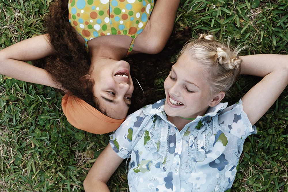 two girls laying on the grass