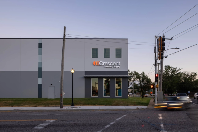 front corner entry of an industrial building with windows seen from the street