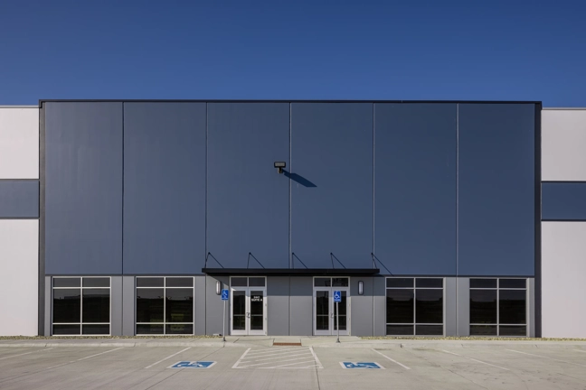 the main entrance of an industrial building with accent color and multiple doors