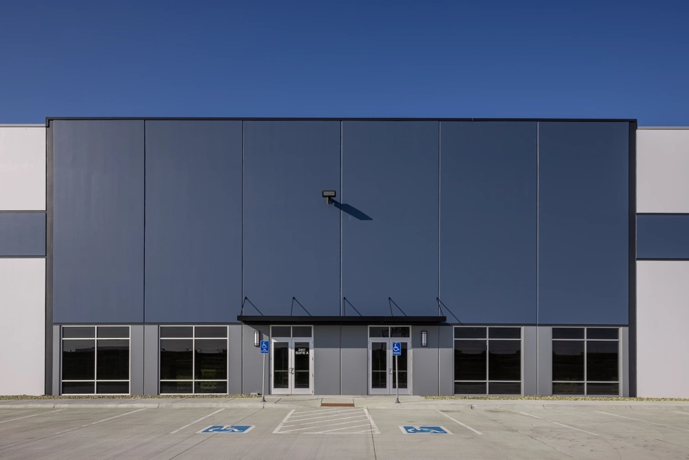 the main entrance of an industrial building with accent color and multiple doors