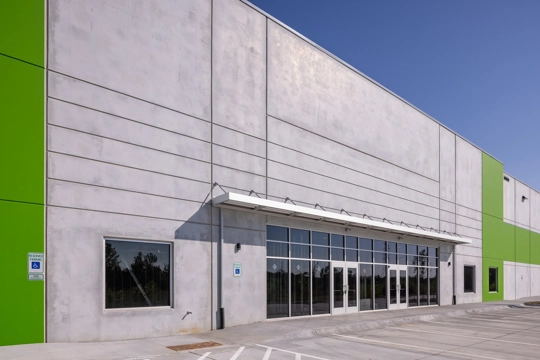 the front entry of an industrial building with doors and glass