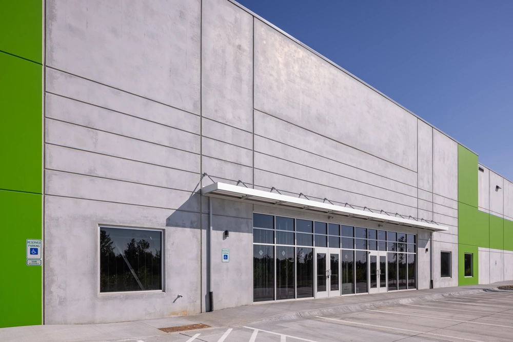 the front entry of an industrial building with doors and glass