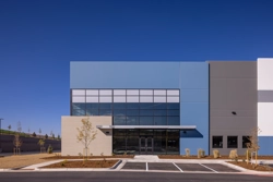 the main corner entrance of an industrial building with a cantilever overhang above the door