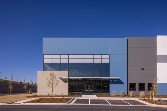 the main corner entrance of an industrial building with a cantilever overhang above the door