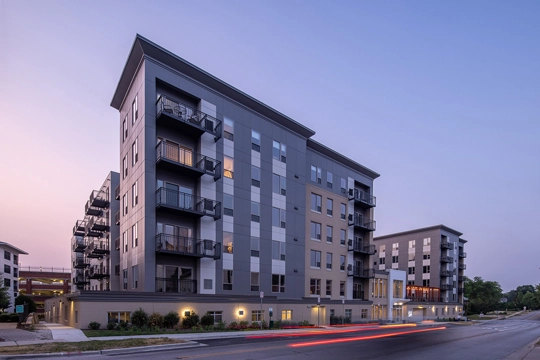 street view of an apartment building at sunset