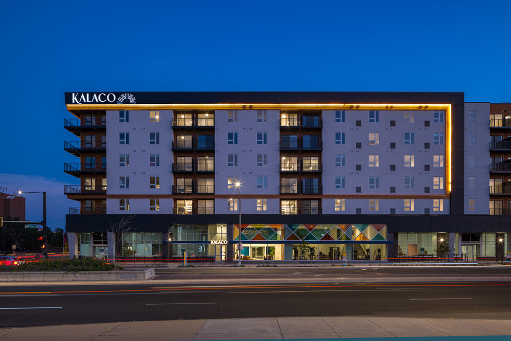 street view of multifamily development with "Kalaco" logo at sunset