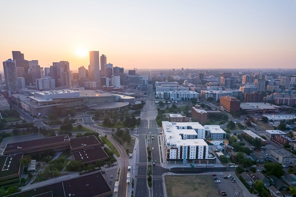 aerial view of multifamily development at sunset with Downtown skyline in background