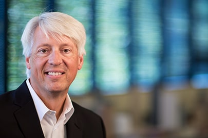 Portrait of a smiling man in professional attire.