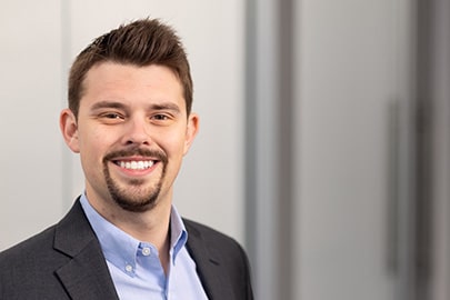 Portrait of a smiling man in professional attire.